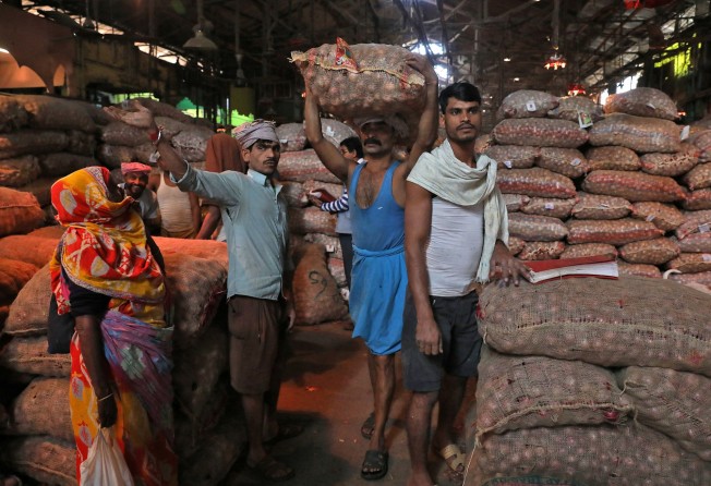 A labourer carries a sack of onions at a wholesale market in Kolkata, India, earlier this month. Photo: Reuters