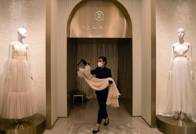 A staff member carrying a dress at a Cong Tri fashion boutique in Ho Chi Minh City. Photo: AFP