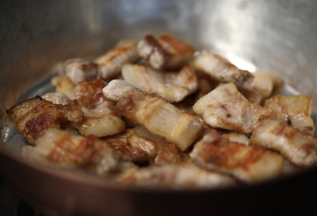 Brown the slices of pork belly in batches. Photo: Jonathan Wong