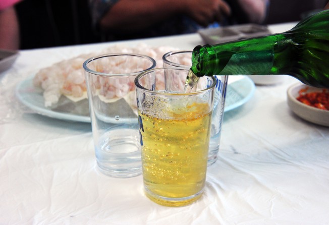 Beer being poured over soju to make somaek. Photo: Shutterstock