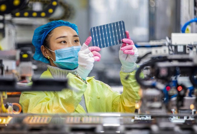 This photo taken on January 7, 2022 shows a worker checking solar photovoltaic modules used for small solar panels at a factory in Haian in China’s eastern Jiangsu province. Photo: AFP