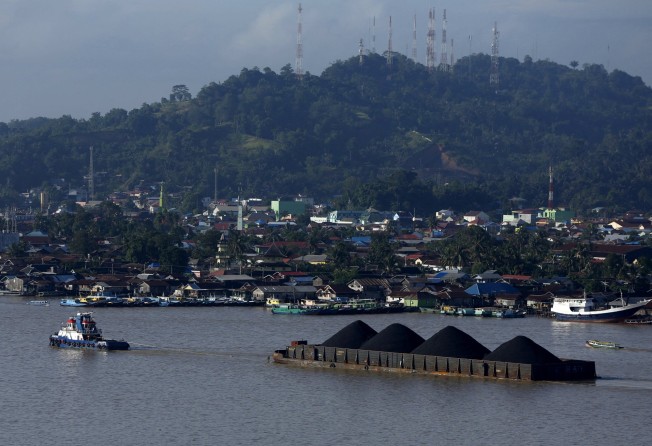 A tug boat pulls a coal barge along the Mahakam river in Samarinda, Indonesia. Photo: Reuters