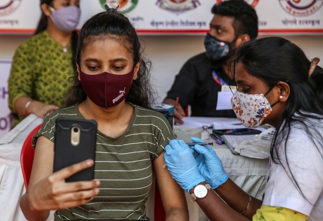 A girl takes a selfie as she receives a Covid-19 vaccine in Mumbai, India. Photo: EPA-EFE