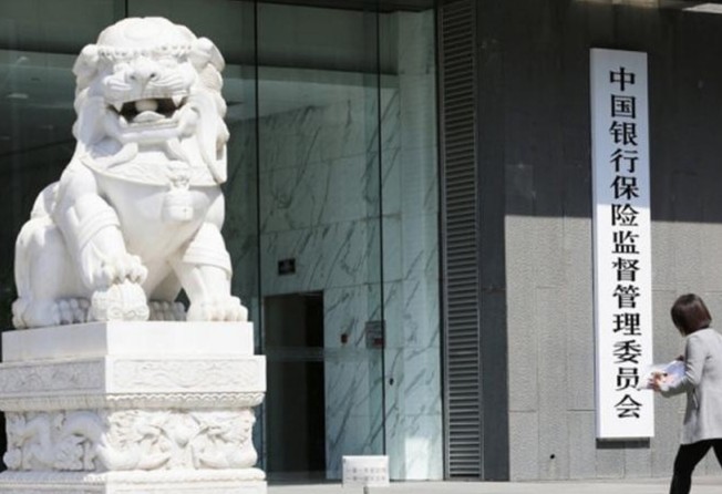 A pedestrian walks past the headquarters of the China Banking and Insurance Regulatory Commission in Beijing. Photo: dfic
