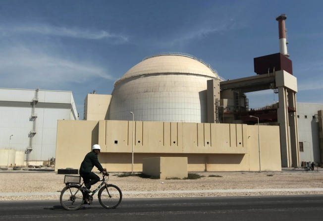 A worker rides a bicycle in front of the reactor building of the Bushehr nuclear power plant, just outside the southern city of Bushehr, Iran in October 2010. Photo: AP