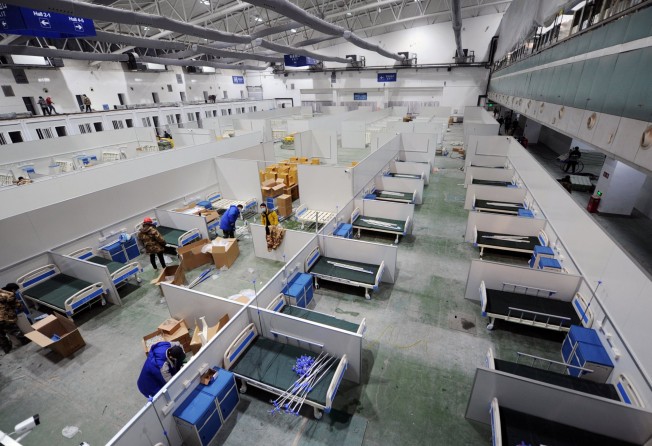 Workers convert an exhibition centre into a makeshift hospital in Changchun. Photo: CNS via Reuters