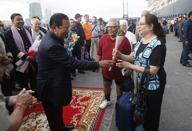 Cambodian Prime Minister Hun Sen distributes roses to passengers as they leave the MS Westerdam cruise ship, in Preah Sihanouk province, Cambodia, on February 14, 2020. Photo: EPA-EFE