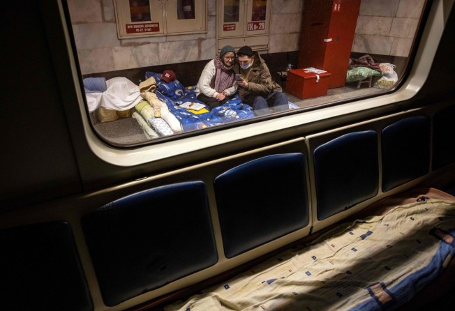 Ukrainian people take refuge in train carriages at a metro station in Kyiv being used as bomb shelter. Photo: AFP
