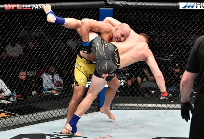 Glover Teixeira (left) takes down Jan Blachowicz of Poland in the UFC light heavyweight championship fight at UFC 267 in Abu Dhabi. Photo: Zuffa LLC