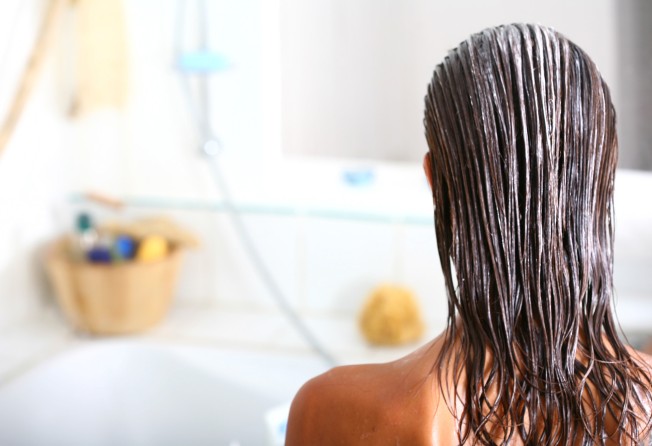 A woman uses a nourishing mask on her hair. Make sure you wash the mask out of your hair thoroughly. Photo: Shutterstock