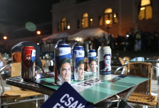 Campaign leaflets for Hungarian opposition leader Peter Marki-Zay are wrapped around beer cans at an election night party in Budapest on Sunday. Photo: AFP