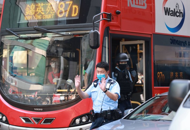 Police officers inspect a bus on Nathan Road after the robbery. Photo: May Tse