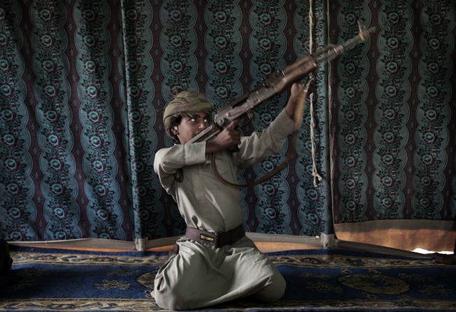 Kahlan, a 12-year-old former child soldier with Yemen’s Houthi rebels, shows how to use a weapon. Photo: AP