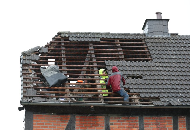 People inspect the damage to a roof on Friday after a tornado hit the city of Lippstadt in Germany. Photo: dpa