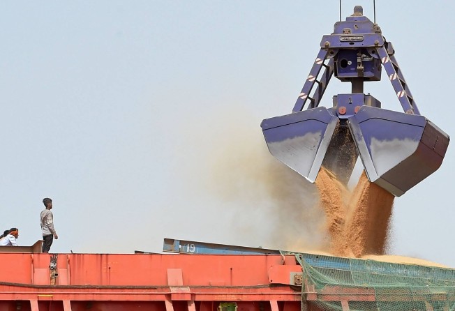 A worker watches wheat being loaded onto a ship at a port in India’s Gujarat state. Traders say abruptly halting exports caused market turmoil. Photo: AFP