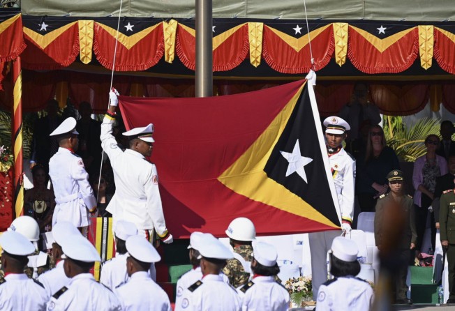 Service members raise East Timor’s national flag in Dili on May 20 during a ceremony marking the anniversary of its independence. Photo: Kyodo