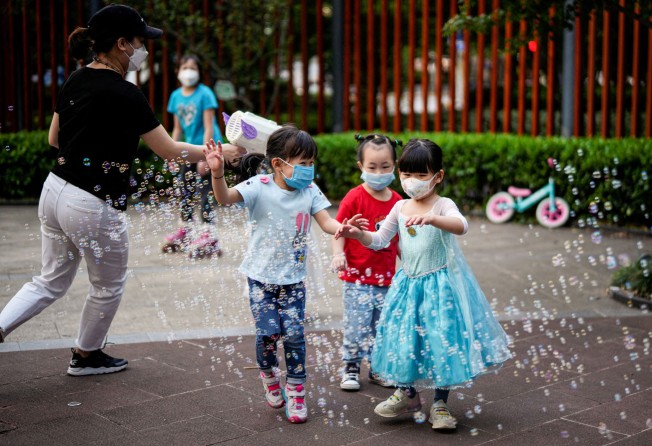 Children wearing protective face masks played amid bubbles at a park in Shanghai on May 31, 2022 on the eve of the formal end of the city’s lockdowns. Photo: Reuters.