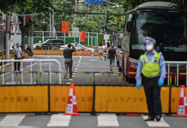 Residents walk on a blocked street in a residential area under a Covid-19 lockdown in the Jing’an district of Shanghai on June 3, 2022. Photo: Agence France-Presse.