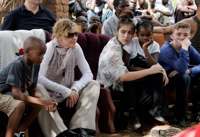 Madonna sitting with her biological and adopted children: David Banda, Lourdes Leon, Mercy James and Rocco. Photo: AFP