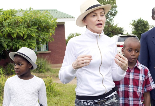 Madonna tours the Mphandura orphanage near Lilongwe, Malawi, with her two adopted children David Banda and Mercy James. Photo: AP