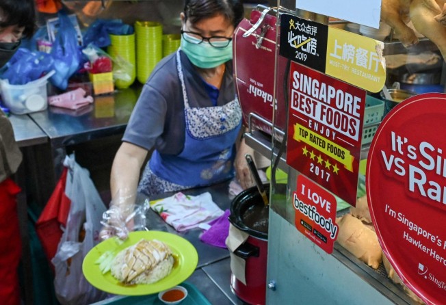 A vendor prepares a plate of chicken rice at a hawker centre in Singapore, before an ban on the export of live chickens from Malaysia caused many such stalls to stop serving the dish. Photo: AFP