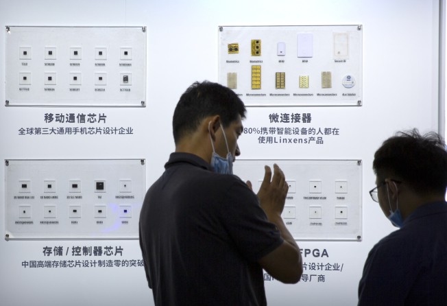 People check out semiconductors on display at the Tsinghua Unigroup booth during the China Beijing International Hi-Tech Expo in Beijing on September 19, 2020. Photo: AP
