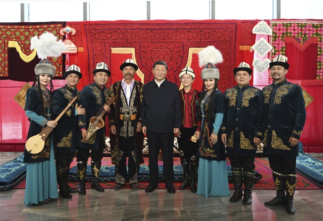 Xi Jinping poses with performers of Manas, a cultural epic of the Kyrgyz people, in Urumqi. Photo: AP