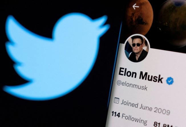 Elon Musk’s Twitter account is seen on a smartphone in front of the Twitter logo. Photo: Reuters