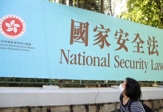A woman looks at a promotional banner for the national security law in Hong Kong on June 30, 2020. Photo: AP