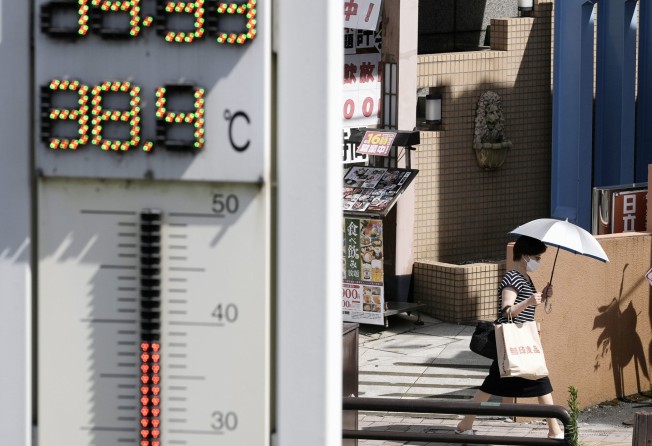 A woman walks with a parasol on a hot day in the Gifu prefecture city of Tajimi, central Japan, on August 2. Photo: Kyodo