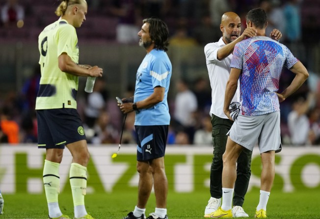 Manchester City’s Erling Haaland (left), coach Pep Guardiola (second right) and Barcelona’s Robert Lewandowski (right) after a friendly match between their clubs on Wednesday. Photo: EPA-EFE