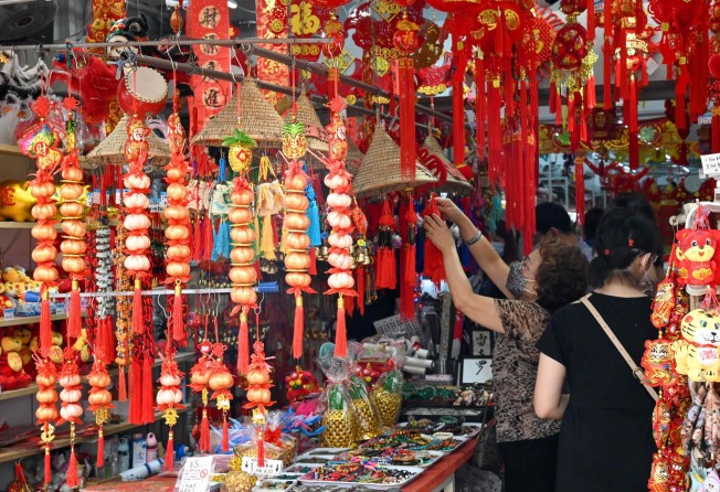 A woman looks at decorative ornaments on the eve of Lunar New Year at the Chinatown district in Singapore in January 2022. Photo: AFP
