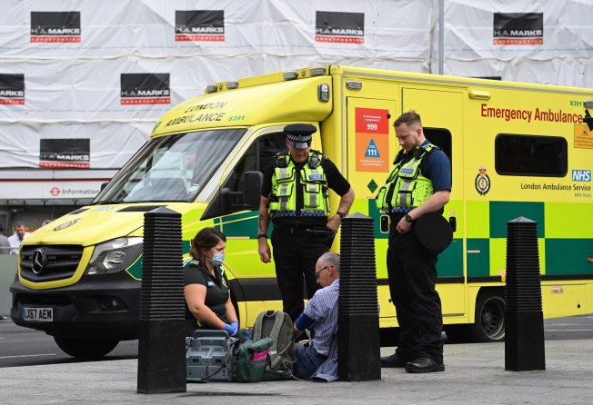 An NHS ambulance crew assist a patient in London. Photo: EPA-EFE