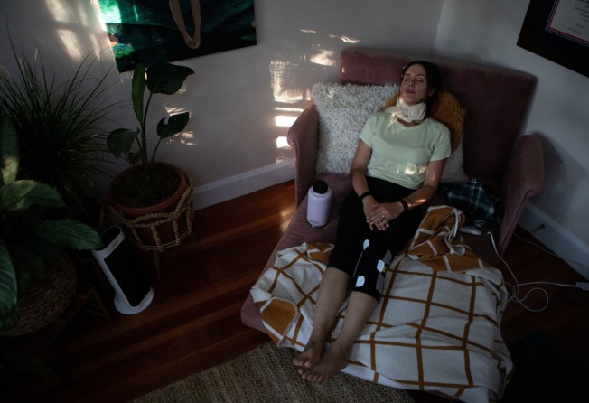 Lauren Nichols, who has long Covid, takes a break and rests in a lounge bed in the office in her home in the US. Photo: Reuters