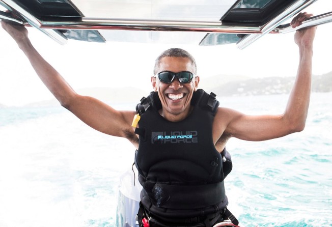 Former US President Barack Obama sits on a boat during a kite surfing outing with British businessman Richard Branson during his holiday in the British Virgin Islands, in February 2017. Photo: Reuters