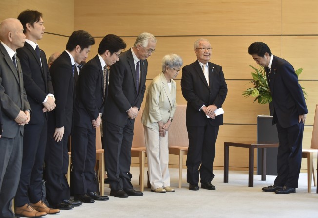 Shinzo Abe (right), Japan’s prime minister at the time (2018), bows to families of Japanese people abducted by North Korea, including Sakie Yokota (third from right). Photo: via AP