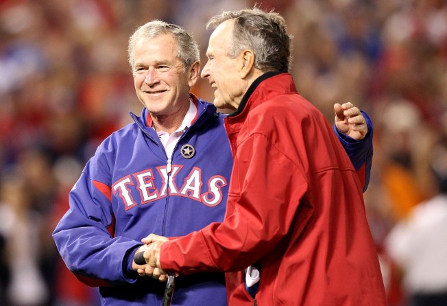 Former US President George W. Bush, embraces his father at the 2010 MLB World Series at Rangers Ballpark. Photo: Getty Images