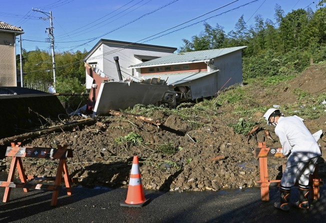 A worker places a barricade at the scene of a landslide in Hamamatsu, Japan’s Shizuoka Prefecture, on Saturday. Photo: Kyodo News via AP
