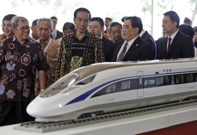 Indonesian President Joko Widodo, centre, inspects a model of the high-speed train which will Jakarta to the country’s fourth largest city, Bandung during the groundbreaking ceremony for the construction of its railway in West Java, Indonesia on January 21, 2016. Photo: AP/File