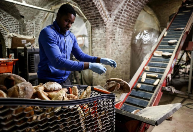 An Eclo worker puts bread into a machine to produce substrate in which to grow organic mushrooms. Photo: AFP