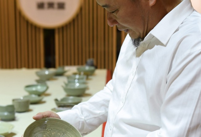 A researcher investigates an example of Longquan porcelain. Photo: Xinhua