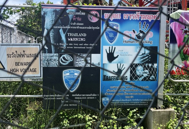Signs on the Thai side of the border crossing warn about human trafficking. Photo: Nathan Paul Southern