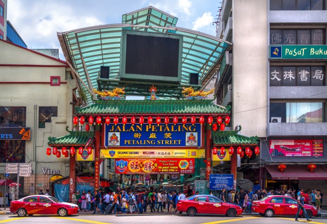 Crowds pass below the main gate of Chinatown at Petaling Street. Enforcement officers from the Kuala Lumpur Islamic religious authorities, accompanied by police officers, detained 20 people from a private party held in Kuala Lumpur’s Chinatown on Saturday. Photo: Shutterstock