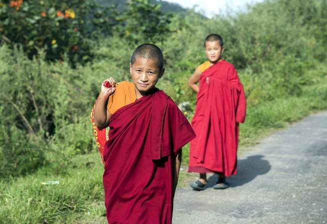 Monks walking near Thinleygang Lhakhang Buddhist temple. Photo: Tim Pile