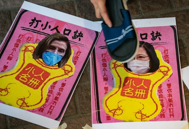 A pro-China supporter hits images of US House of Representatives Speaker Nancy Pelosi and Taiwan President Tsai Ing-wen with a shoe. File photo: TNS
