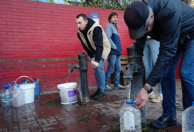 People fill containers with water from public water pumps in Kyiv, Ukraine. Photo: AP