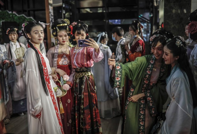 Contestants wearing traditional Chinese clothing pose for selfies after attending a modelling competition at a shopping centre in Beijing in August 2020. Photo: EPA-EFE