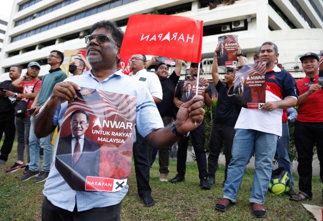 Supporters of PM Anwar Ibrahim celebrate outside the National Palace. Photo: EPA-EFE