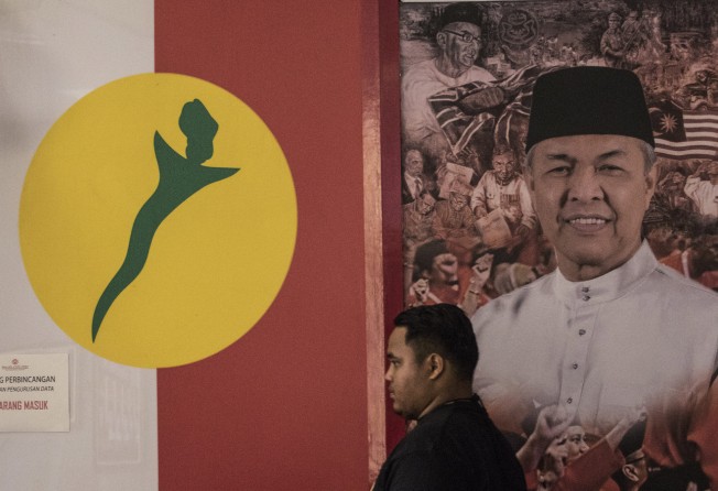 A man stands in front of a picture of Umno president Ahmad Zahid Hamidi at party headquarters in Kuala Lumpur. Photo: AP