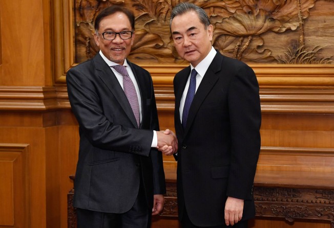Çhina’s Foreign Minister Wang Yi (right) shakes hands with Malaysia’s Anwar Ibrahim in Beijing in October 2018. Photo: Pool/AFP